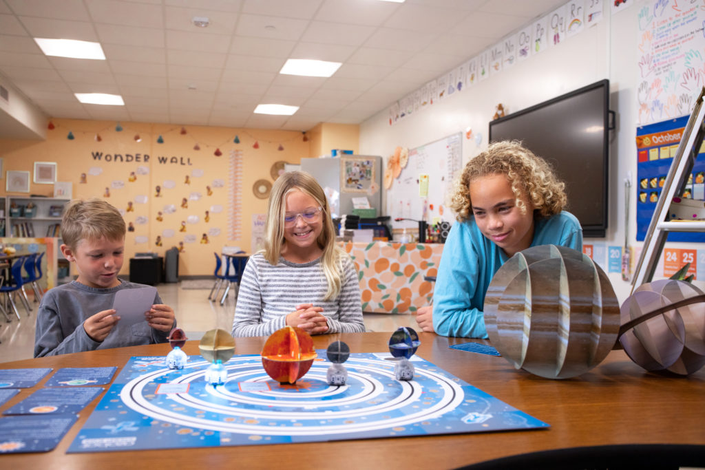 Back to School 2023: Students gather around a table that has OzoGoes to the Solar System STEAM Kit